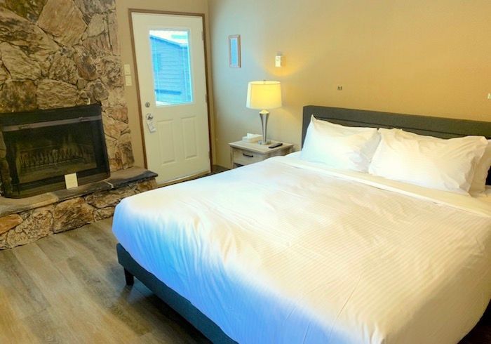 Bedroom with bed, fireplace, nightstand, and door.