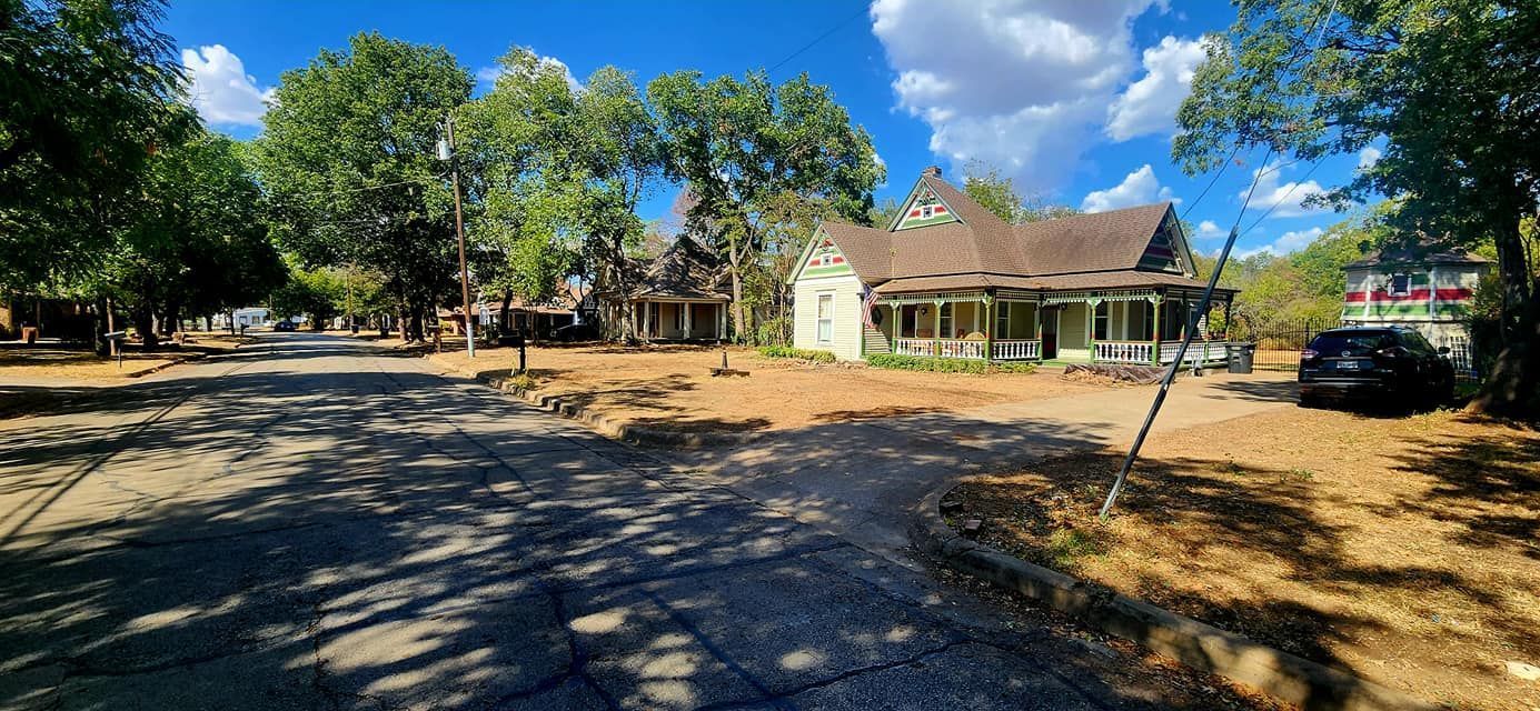 A large house with a car parked in front of it is surrounded by trees. A large house with a car parked in front of it is surrounded by trees.