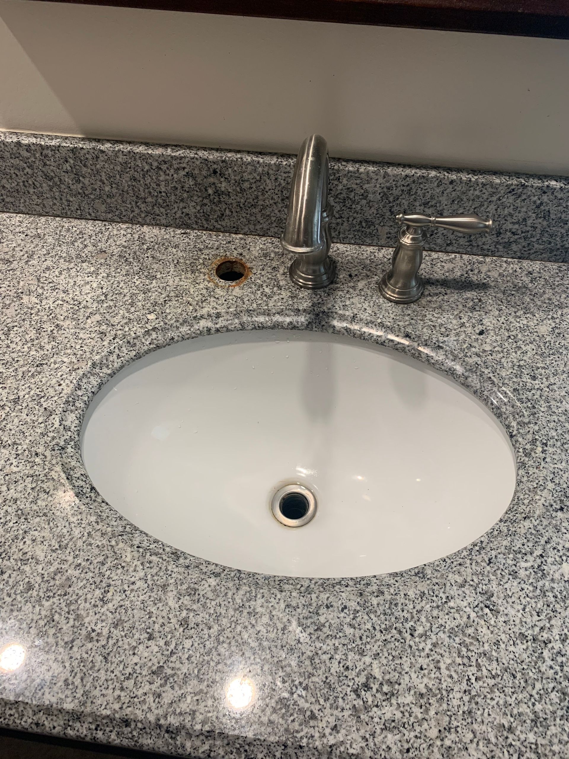 A bathroom sink with a faucet on a granite counter top