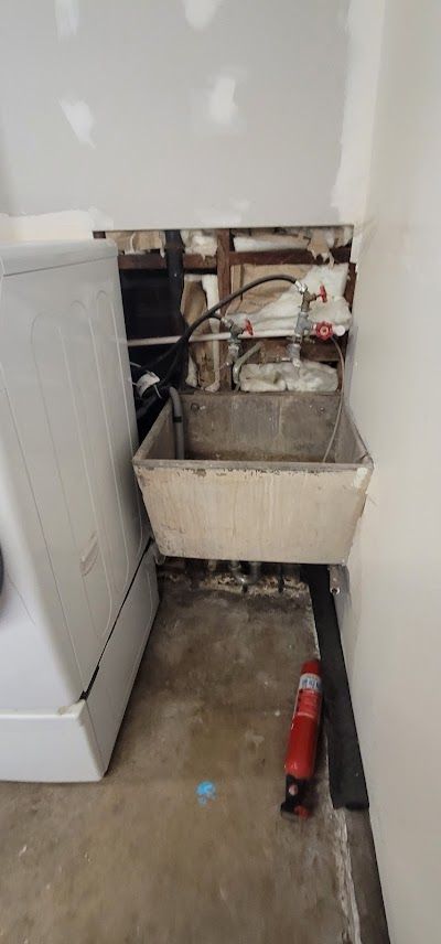 A laundry room with a sink and a washer and dryer.