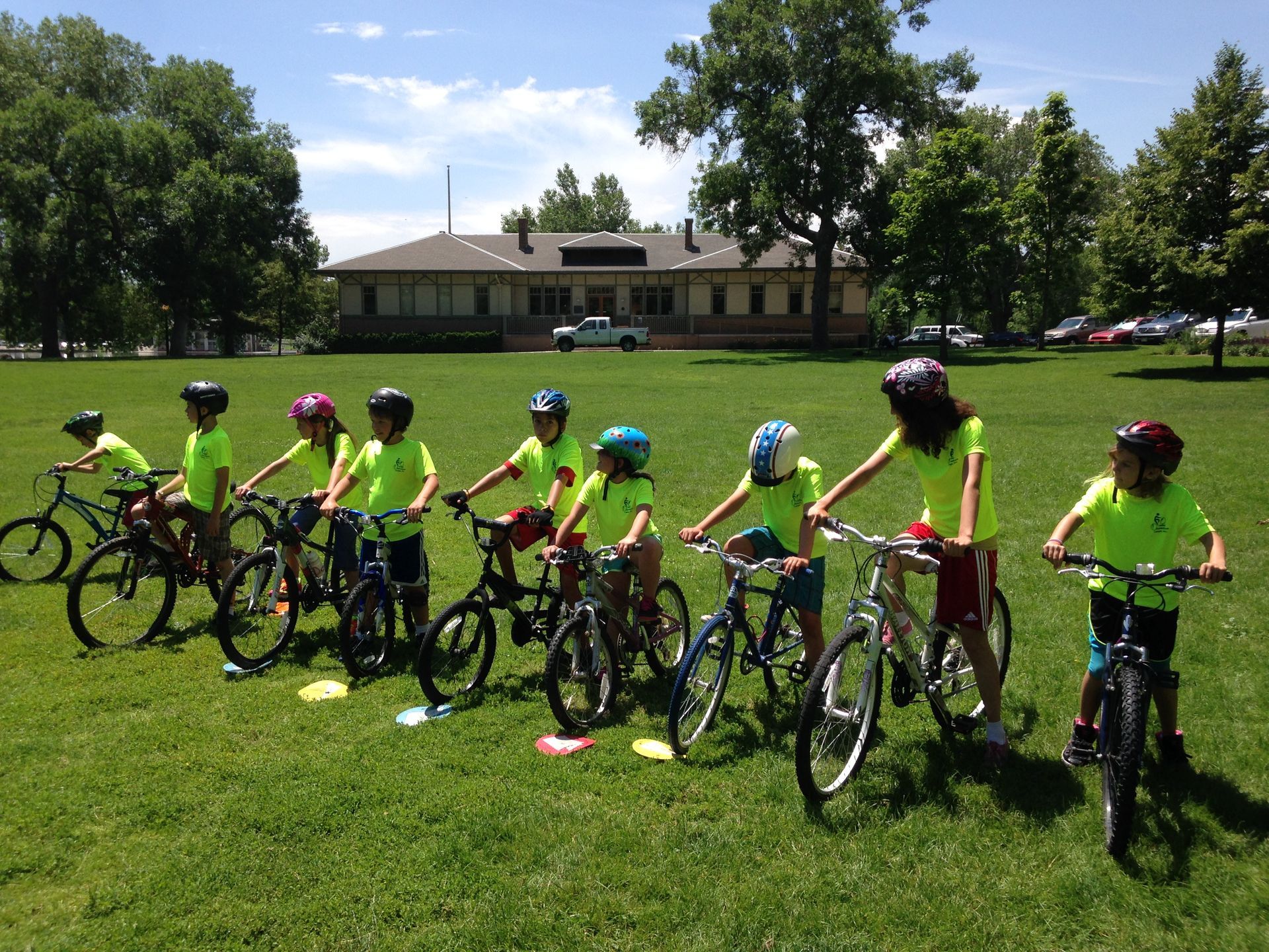 A group of children are riding bikes in a grassy field
