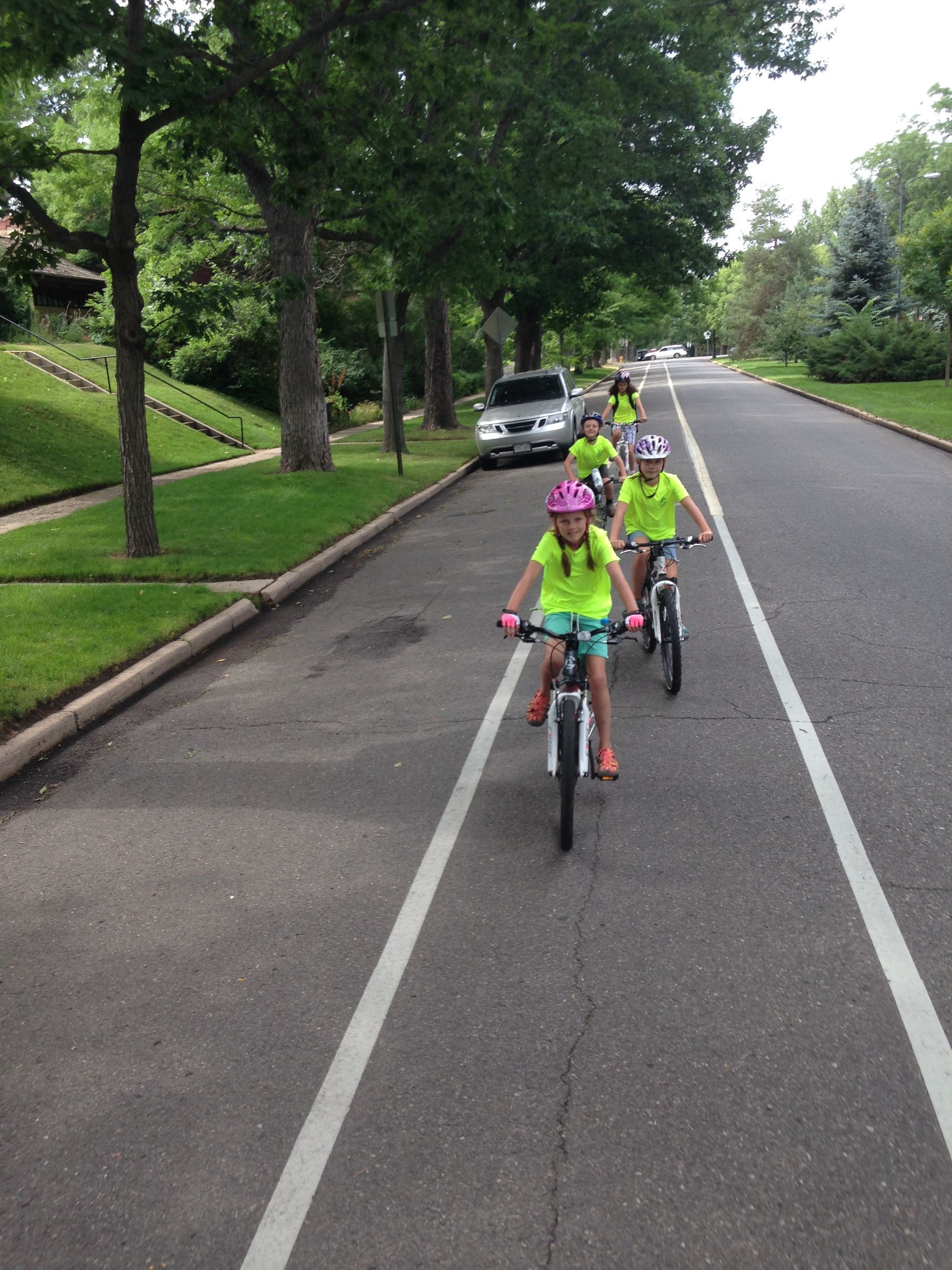A group of children are riding bikes down a street