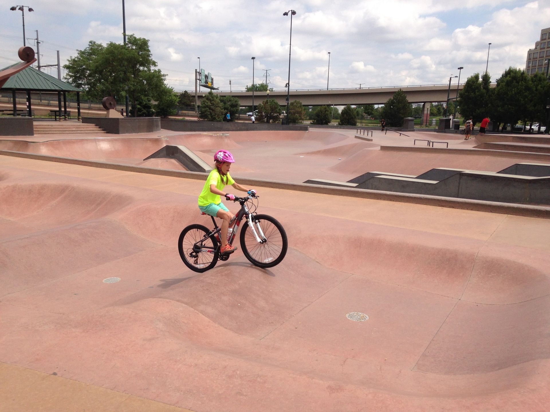 A young girl is riding a bike in a skate park