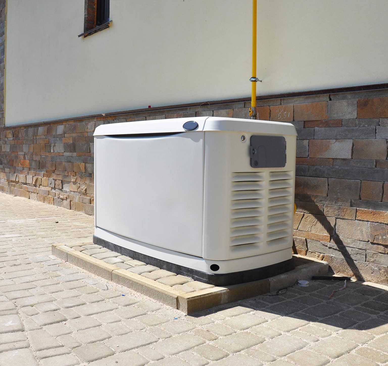 View of a big white gas generator outside a house, showcasing generator installation. View of a big white gas generator outside a house, showcasing generator installation.