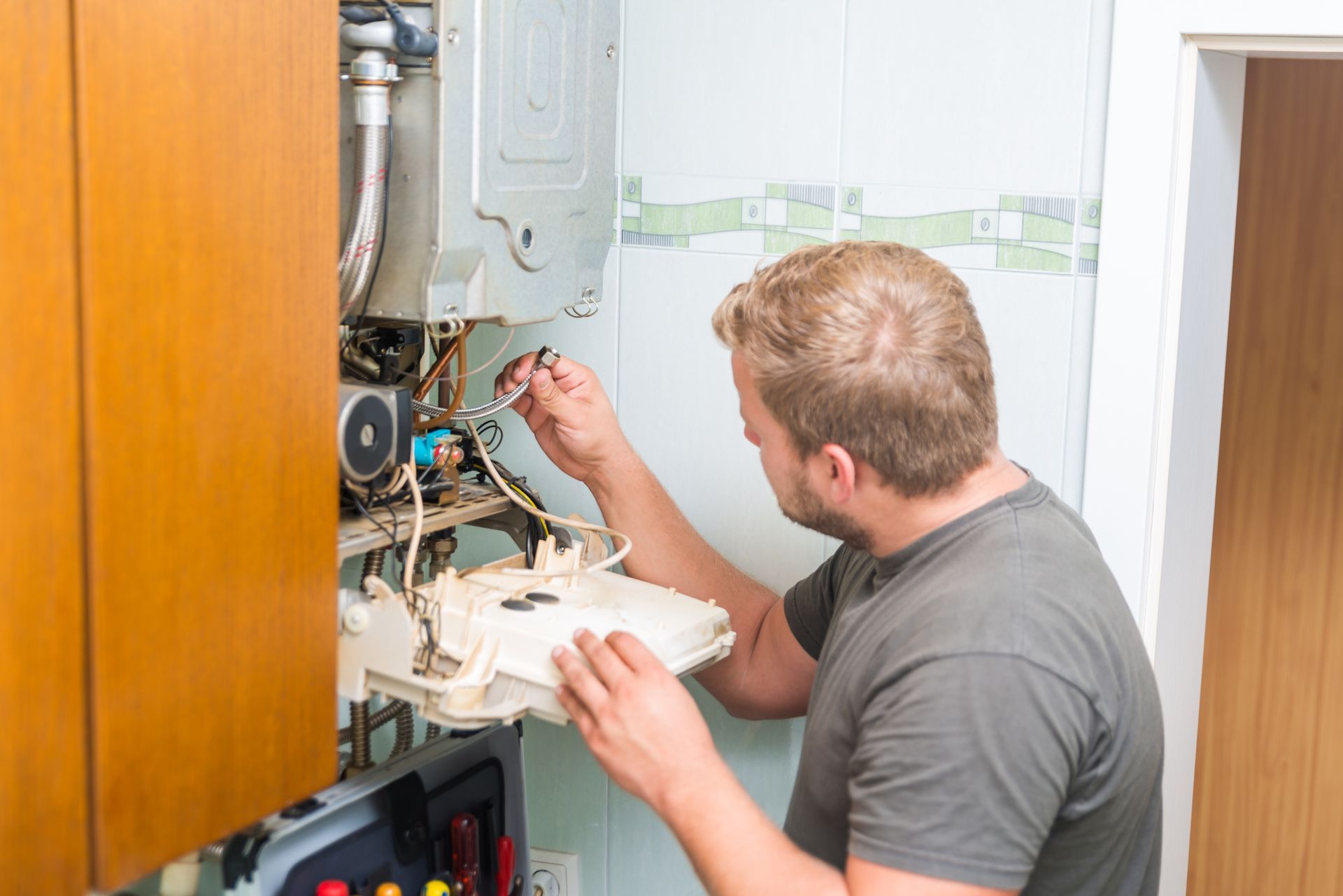 A man is inspecting a gas furnace. A man is inspecting a gas furnace.