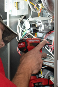 Technician performing furnace maintenance.