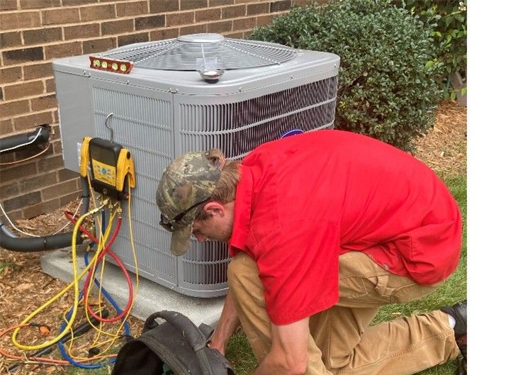 An AC Installer works on a home's air conditioner unit outdoors