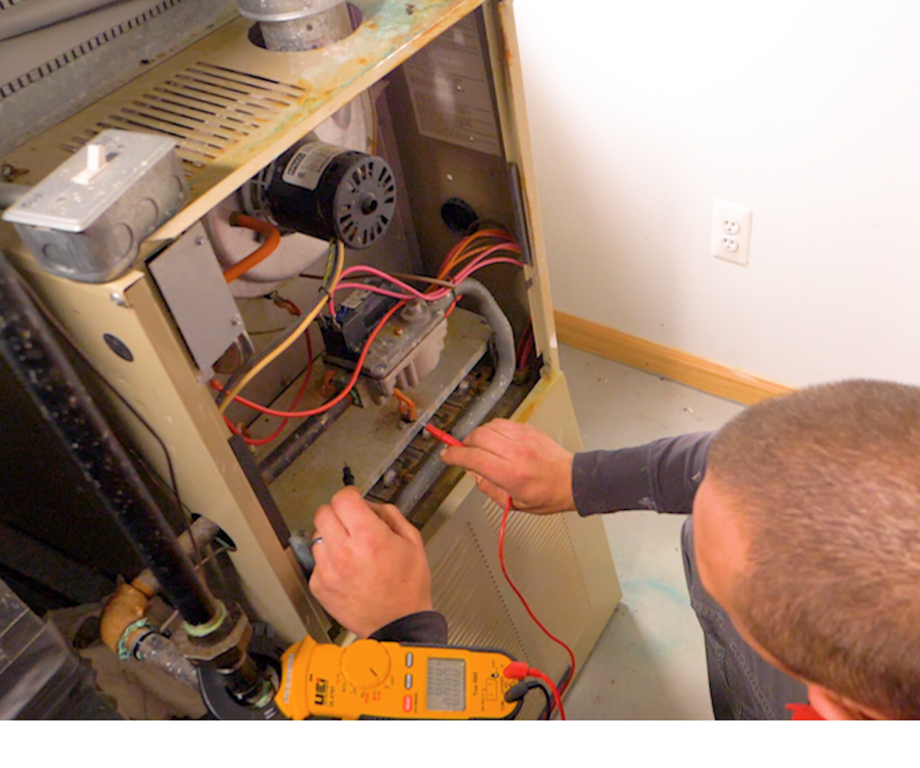Technician testing an older model furnace.