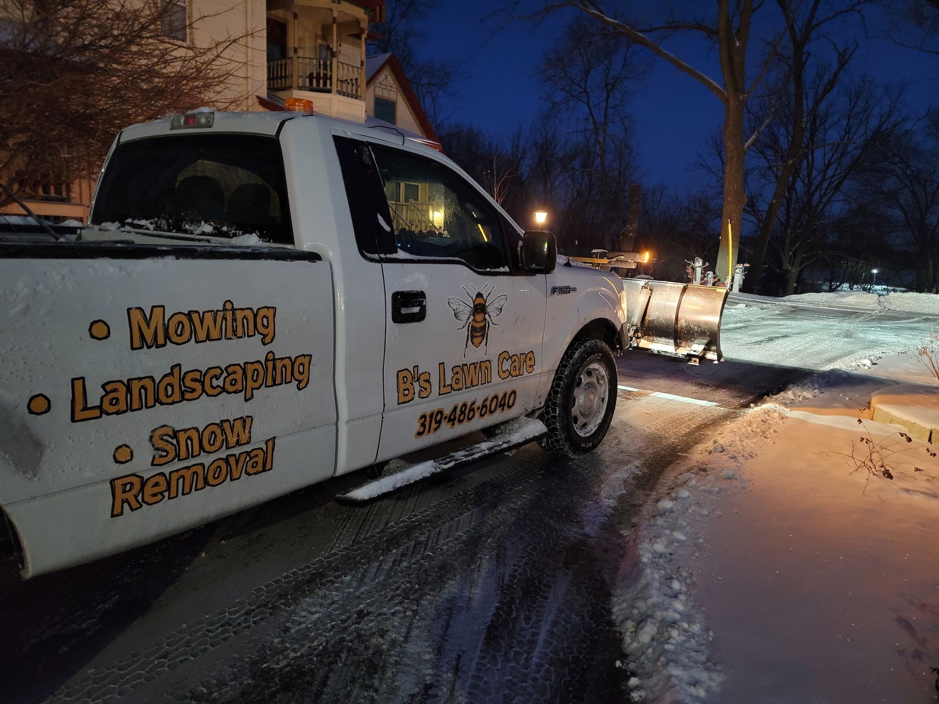 A white truck is parked on the side of the road in the snow.