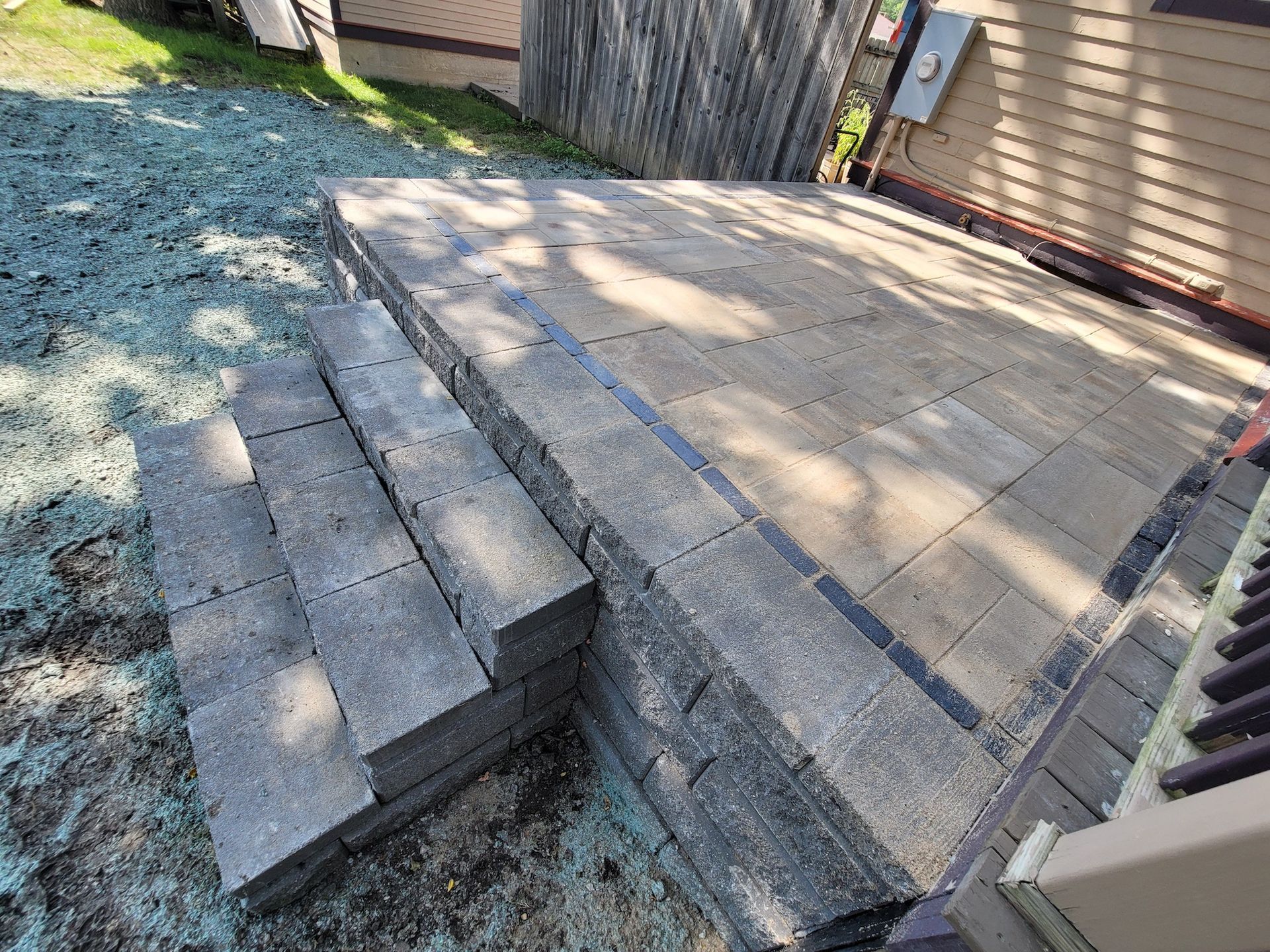 A set of stairs leading up to a patio next to a house.