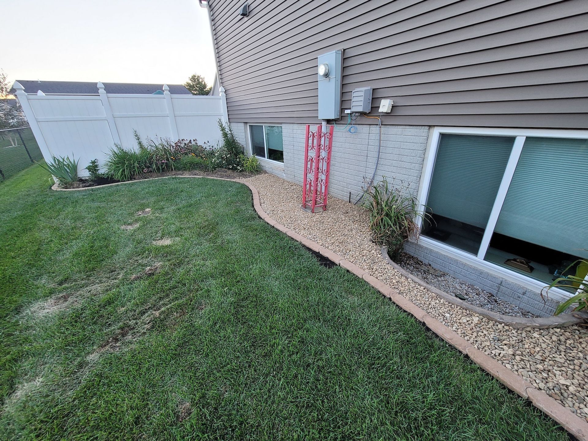 A house with a lot of windows and a fence in the backyard.