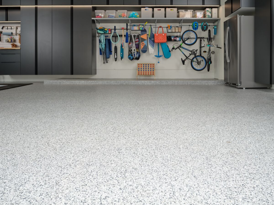 Garage with a polished epoxy floor coating, custom cabinets, and organized hanging racks for bikes.