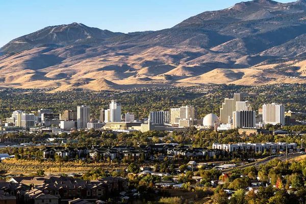 An aerial capture of the downtown area of Reno Nevada and its beautiful mountains and greenery