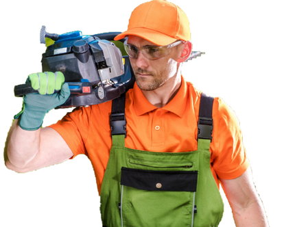 Handsome man in orange and green safety equipment with orange hat holding a chain saw over his shoulder looking into the distance