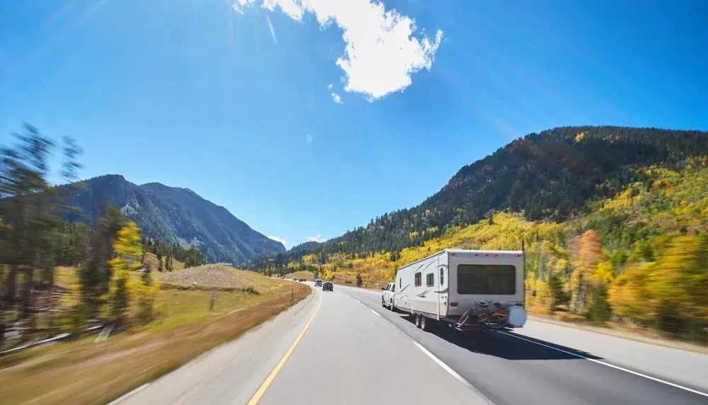 RV Driving on a Highway Through a Mountain Pass on a Sunny Day — Rod's Engineering & Lifetime Trailers in Bli Bli, QLD