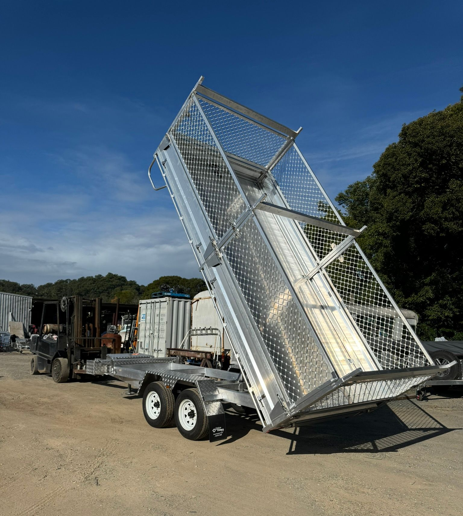 Black Dumpster Trailer Parked in a Driveway — Rod's Engineering & Lifetime Trailers in Bli Bli, QLD