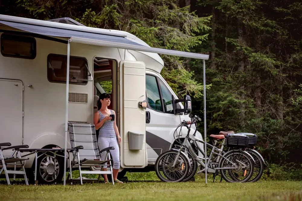 Woman Near a White Rv With Awning — Rod's Engineering & Lifetime Trailers in Bli Bli, QLD