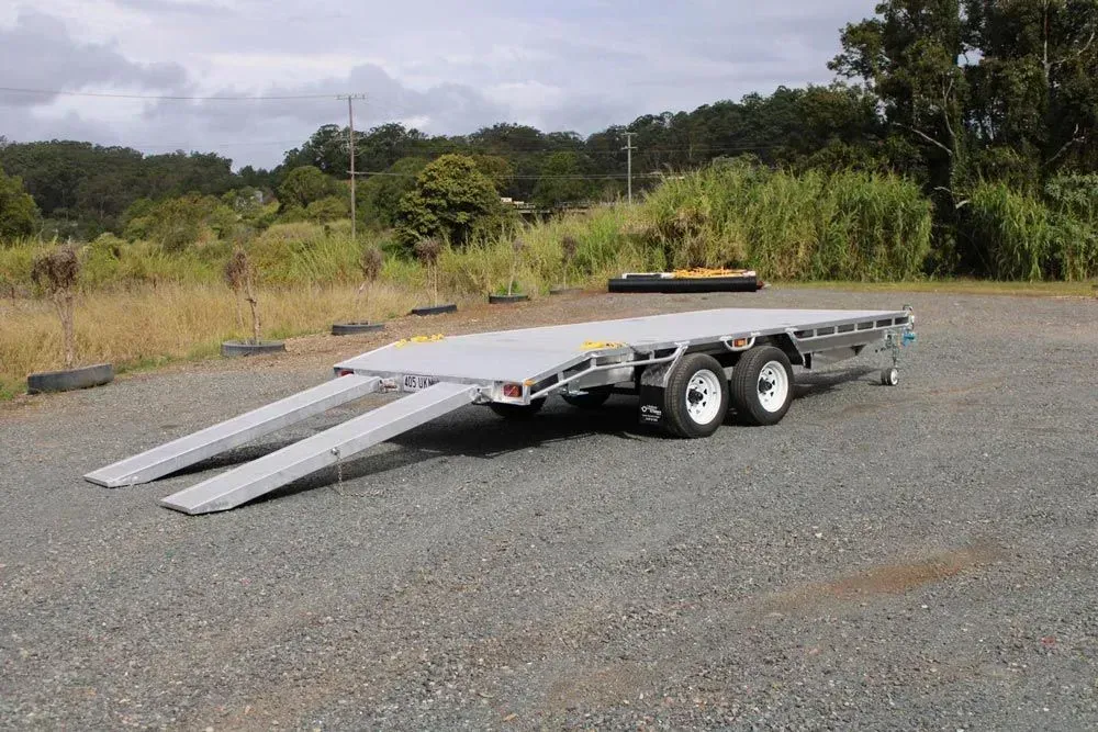 Flatbed Trailer With Loading Ramps on a Gravel Surface — Rod's Engineering & Lifetime Trailers in Bli Bli, QLD