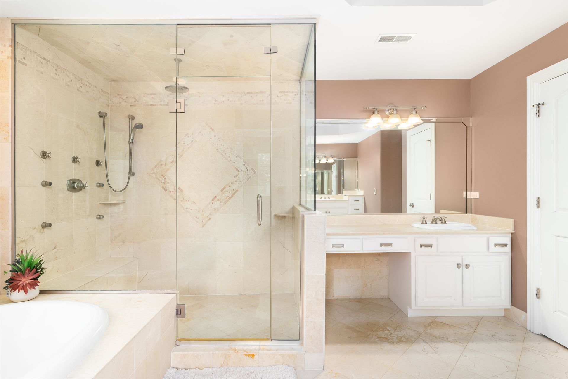 A beautiful bathroom with a glass shower door, bathtub, white vanity cabinet, and mirror. A beautiful bathroom with a glass shower door, bathtub, white vanity cabinet, and mirror.
