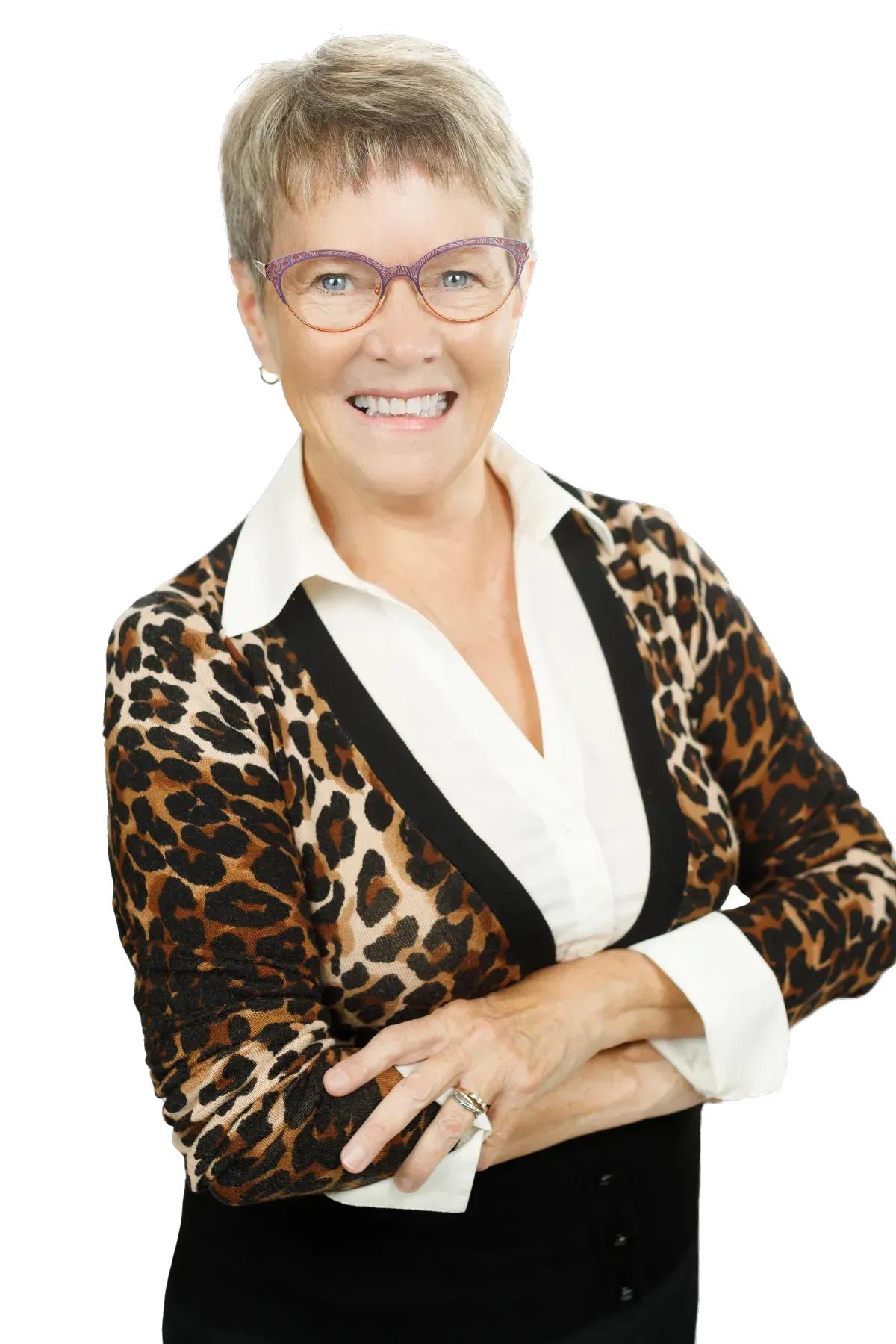 Woman with glasses and a leopard print sweater smiles with arms crossed.