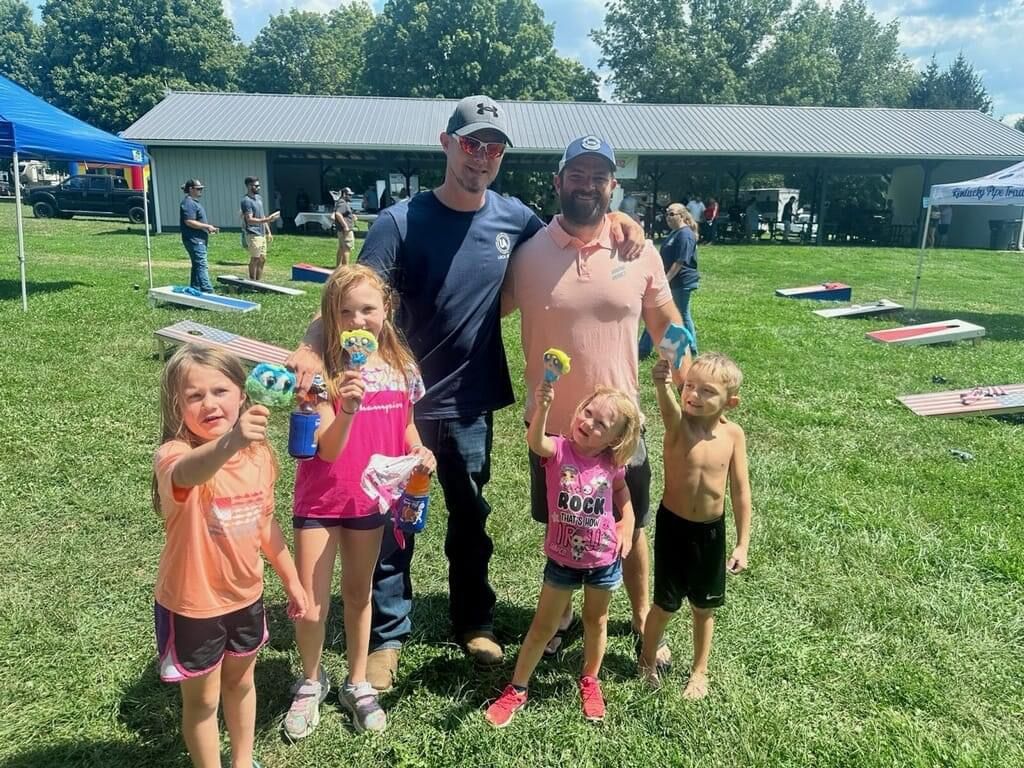 A group of people are standing in a grassy field.