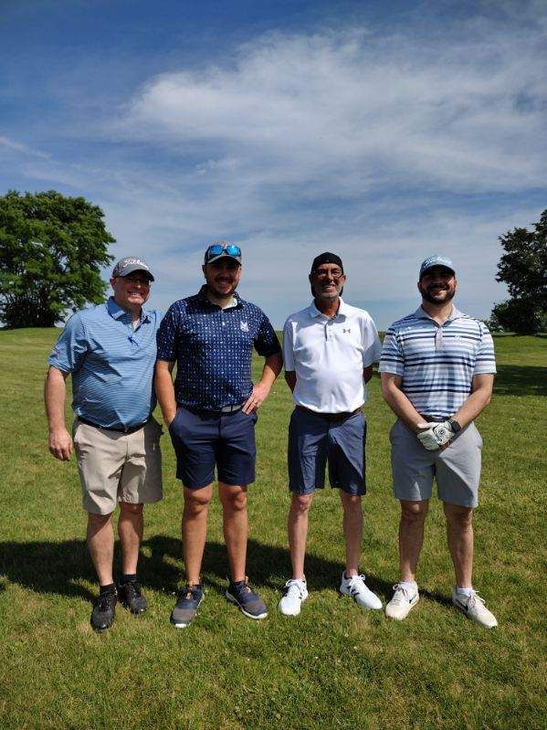 A group of men are posing for a picture on a golf course.