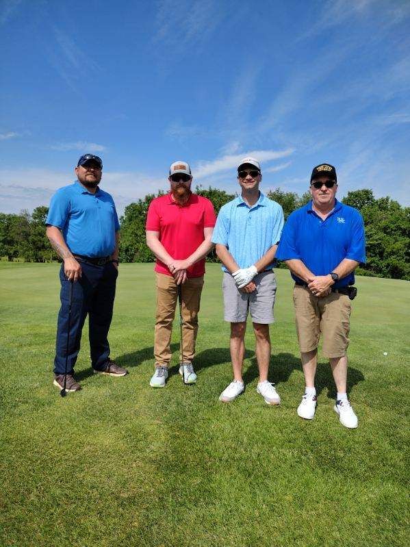 A group of men are standing on a golf course.