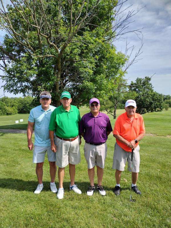 A group of men are posing for a picture on a golf course.
