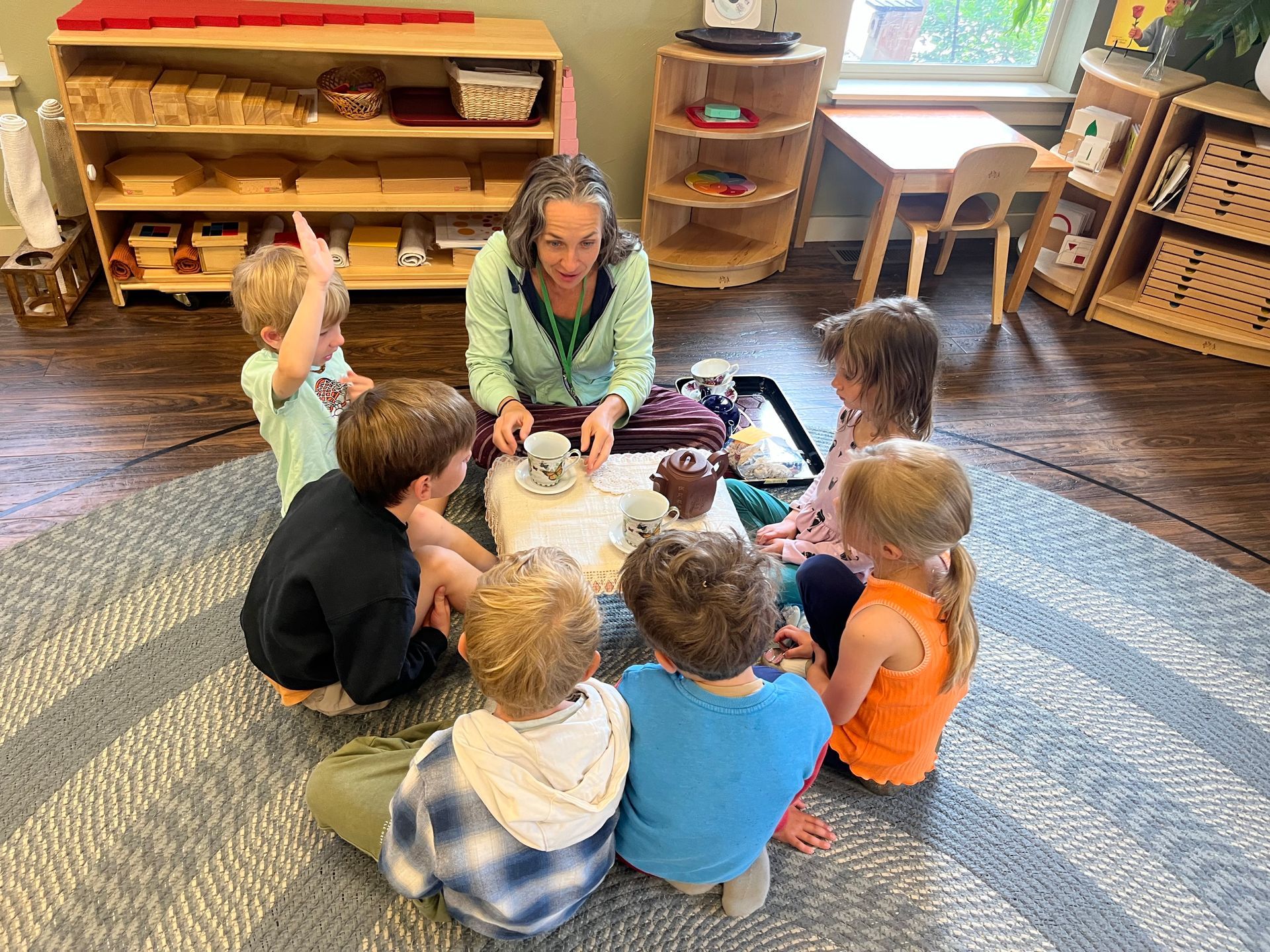 montessori children with guide in tea lesson