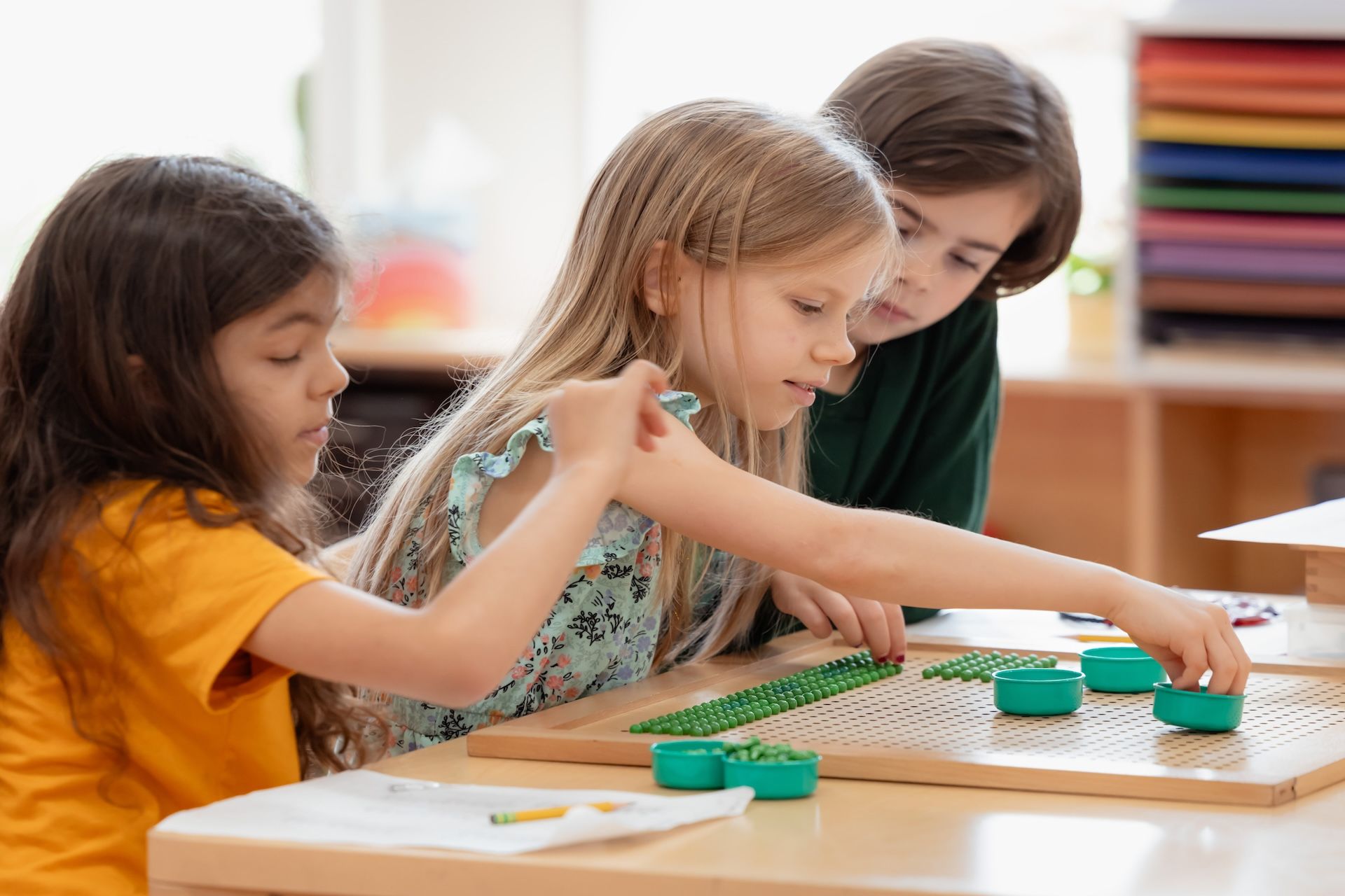 A group of children are sitting at a table playing with toys.