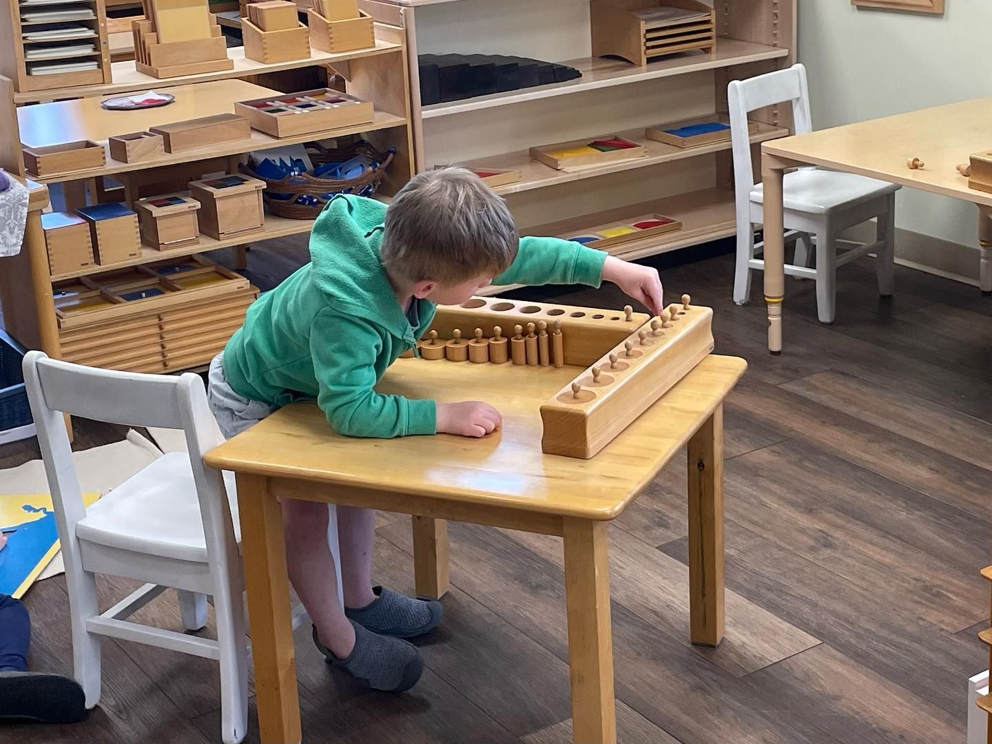montessori child working with knobbed cylinders