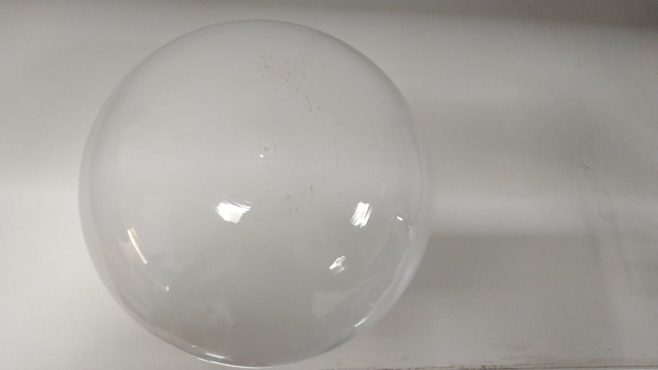 Una bombilla grande, blanca y con forma de huevo, de superficie brillante que refleja el entorno.