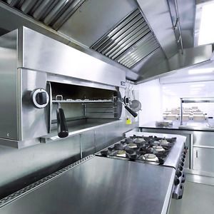 Une cuisine en acier inoxydable avec une cuisinière et un four.