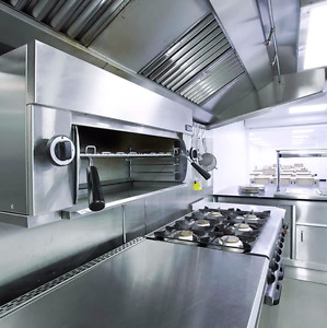 Une cuisine en acier inoxydable avec une cuisinière et un four