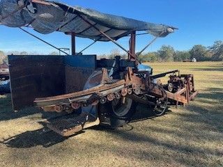 A tractor is parked in a field with a tarp on top of it.