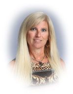 Woman with long blonde hair, wearing a patterned top, smiling at the camera against a light background.