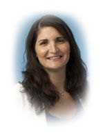 Woman with dark hair smiles, wearing a white jacket, in front of a blue background.
