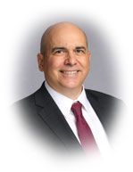 Bald man in suit smiling, burgundy tie, studio portrait.