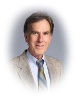 Man in light jacket and tie, smiling, portrait.