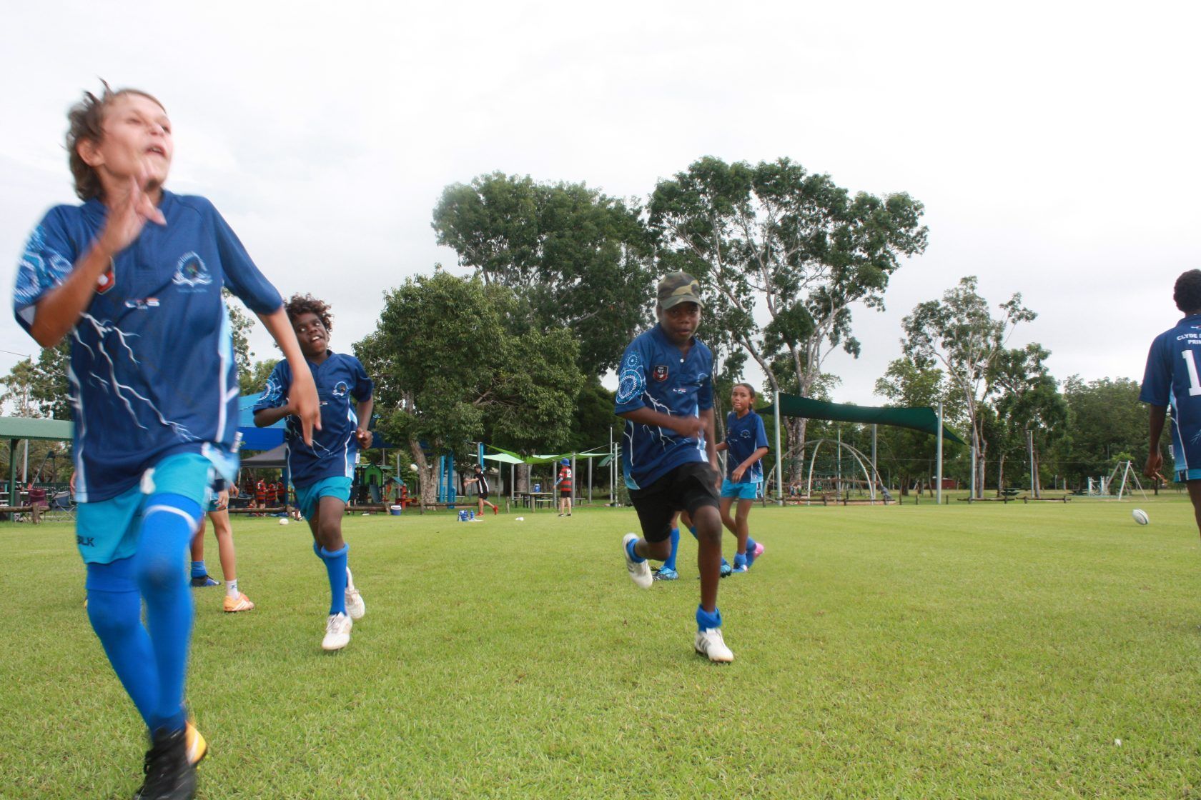 A group of soccer players are running on a field