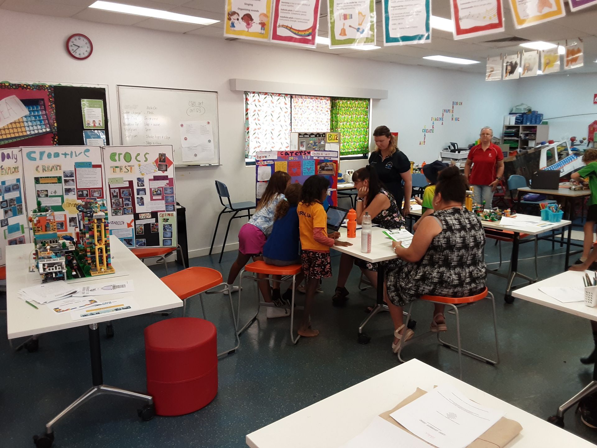 A group of people are sitting at tables in a classroom.
