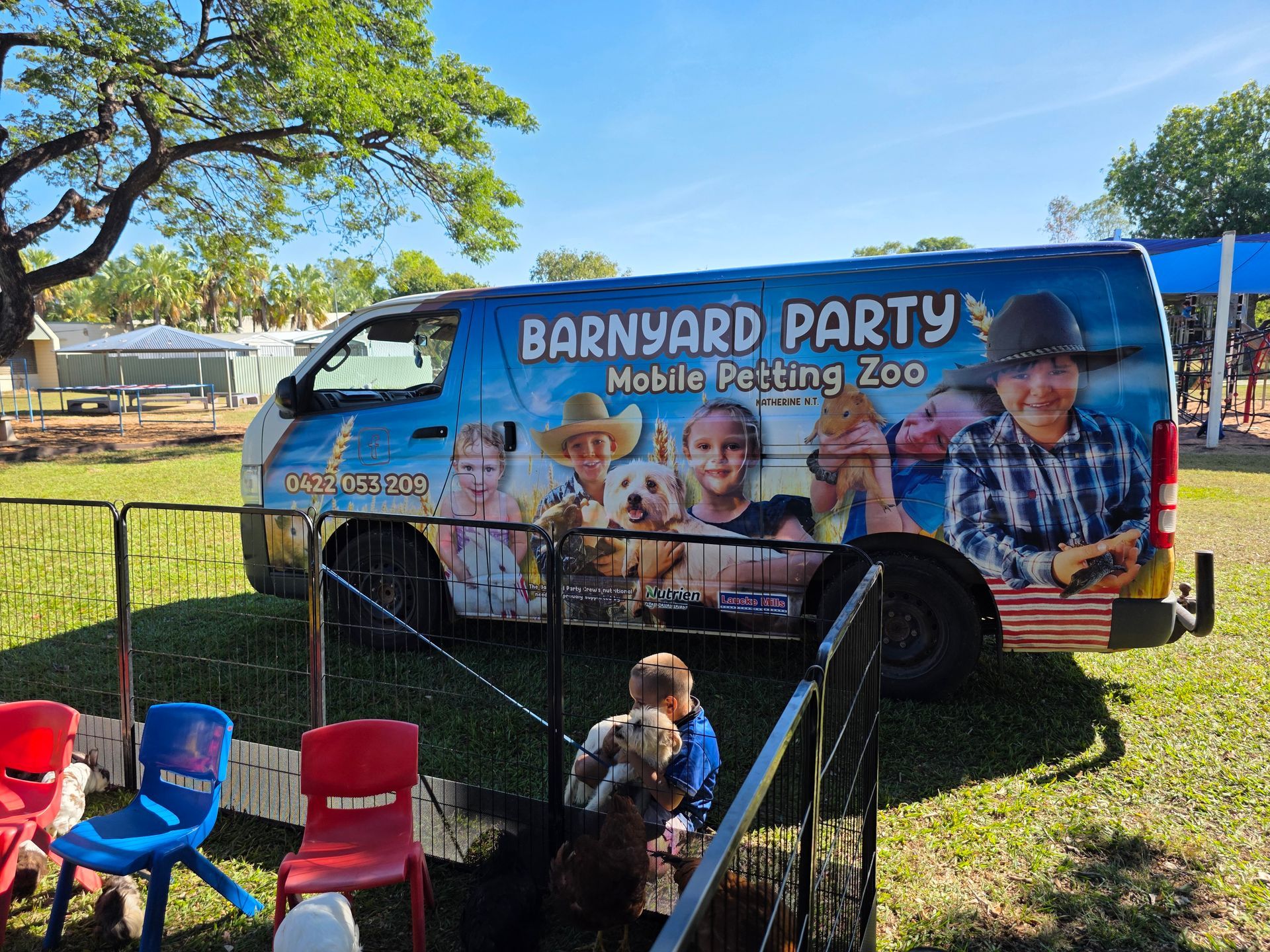 A barnyard party van is parked in a grassy field.