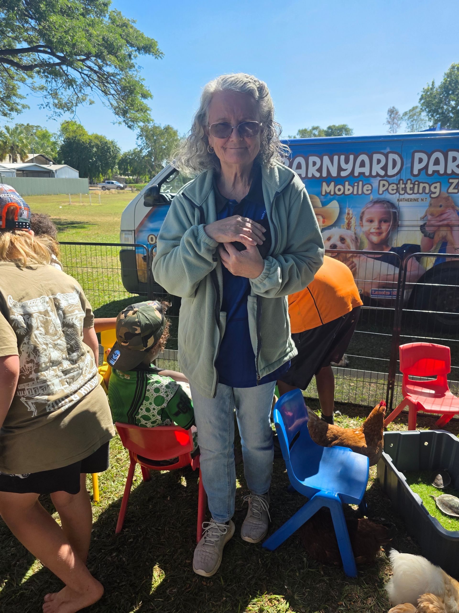 A woman is standing in front of a sign that says barnyard park