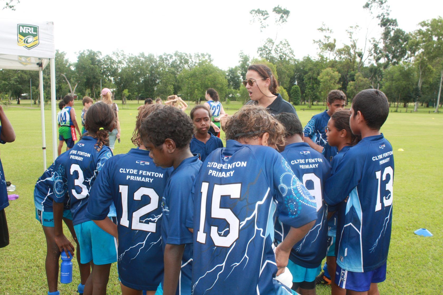 A group of children wearing blue shirts with the number 15 on the back
