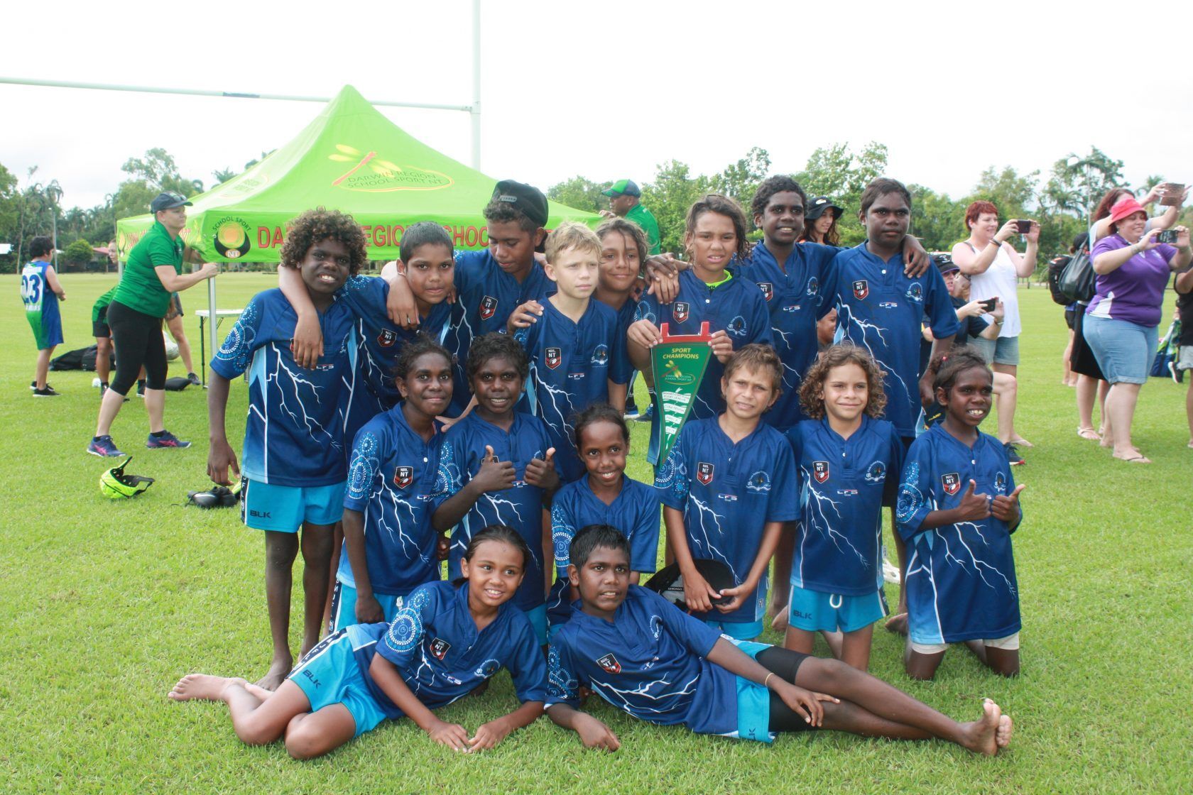 A group of children are posing for a picture on a field.