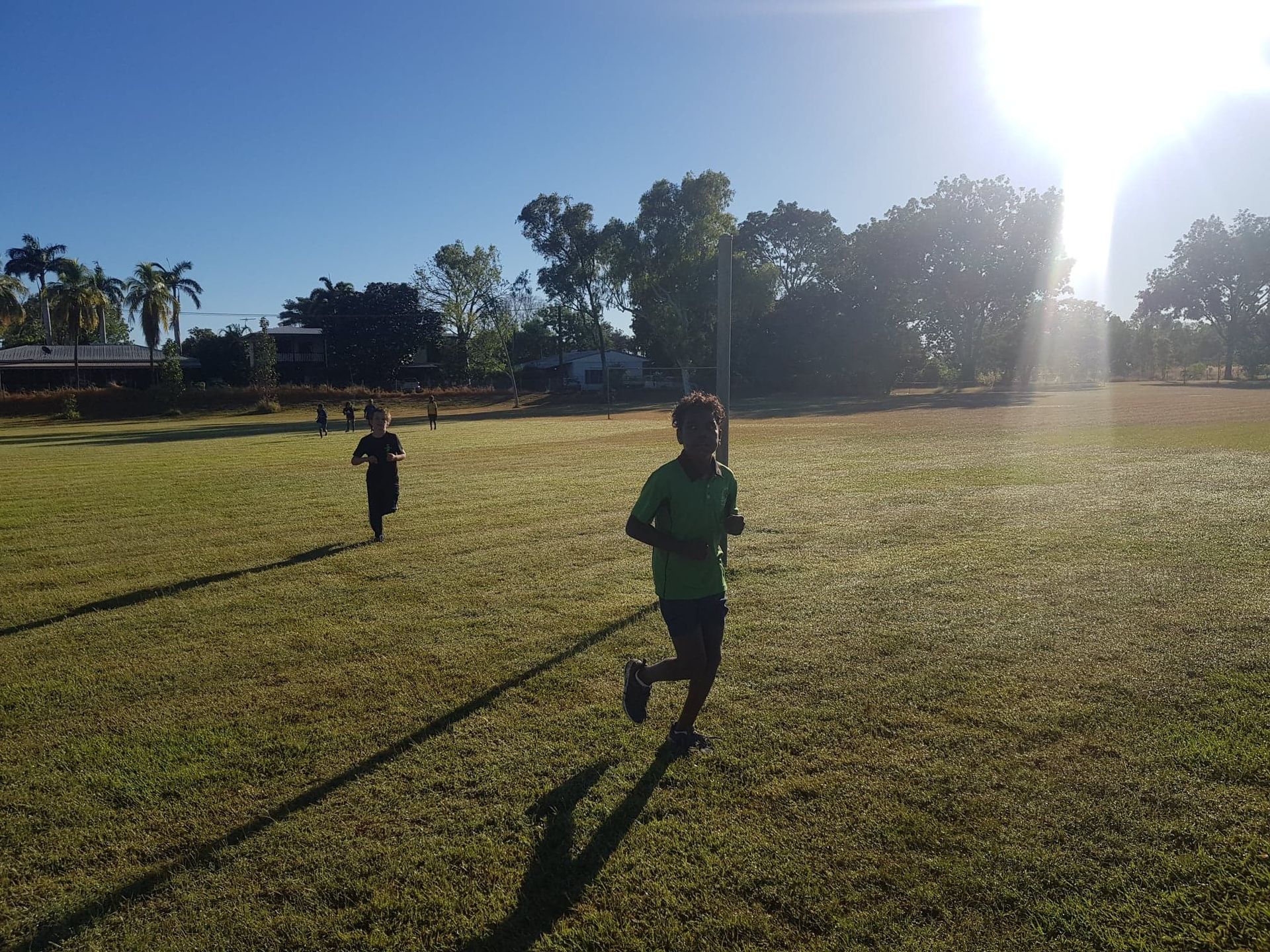 Two children are running in a grassy field.