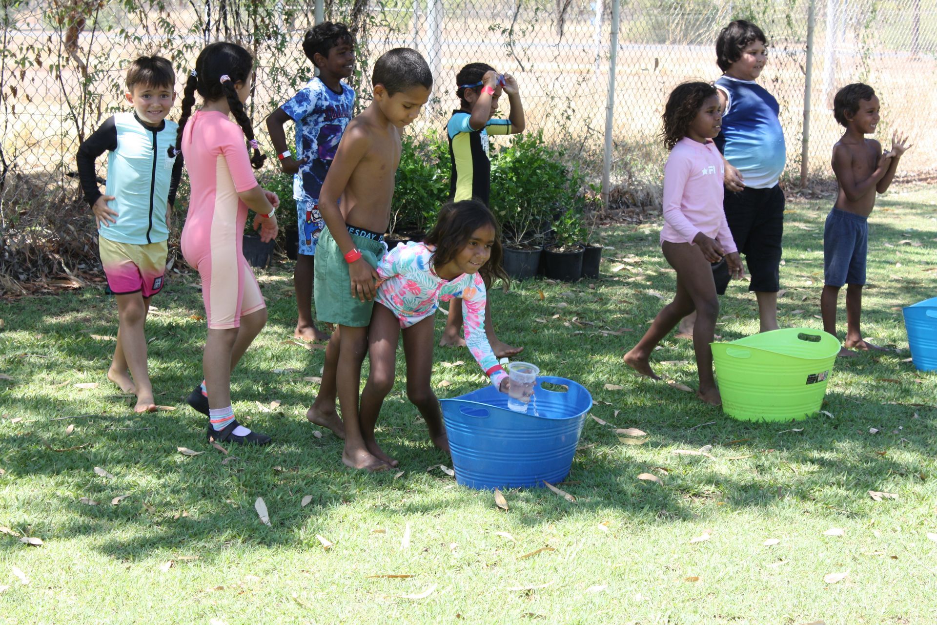 A group of children are playing in buckets of water.