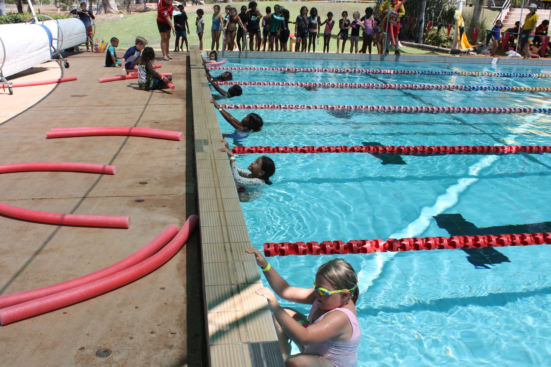 A group of children are swimming in a swimming pool