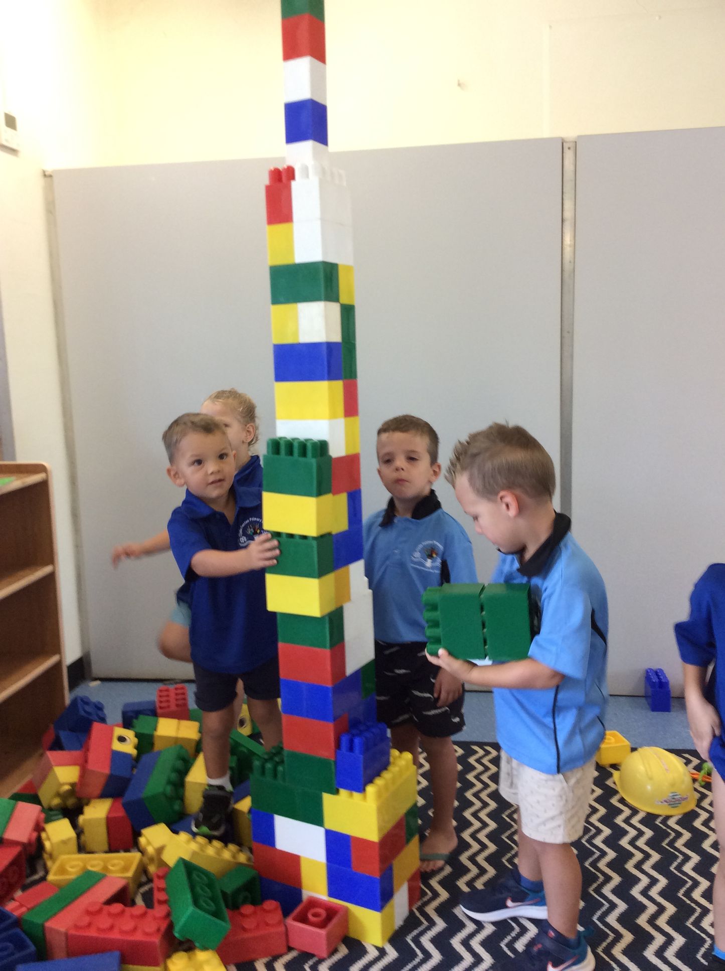A group of children are playing with lego blocks in a room.