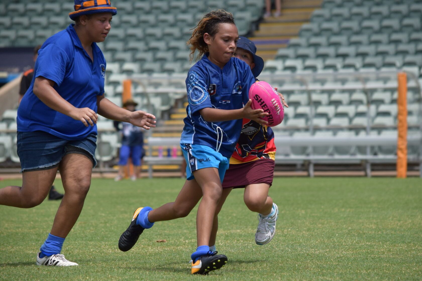 A group of young girls are playing rugby on a field.